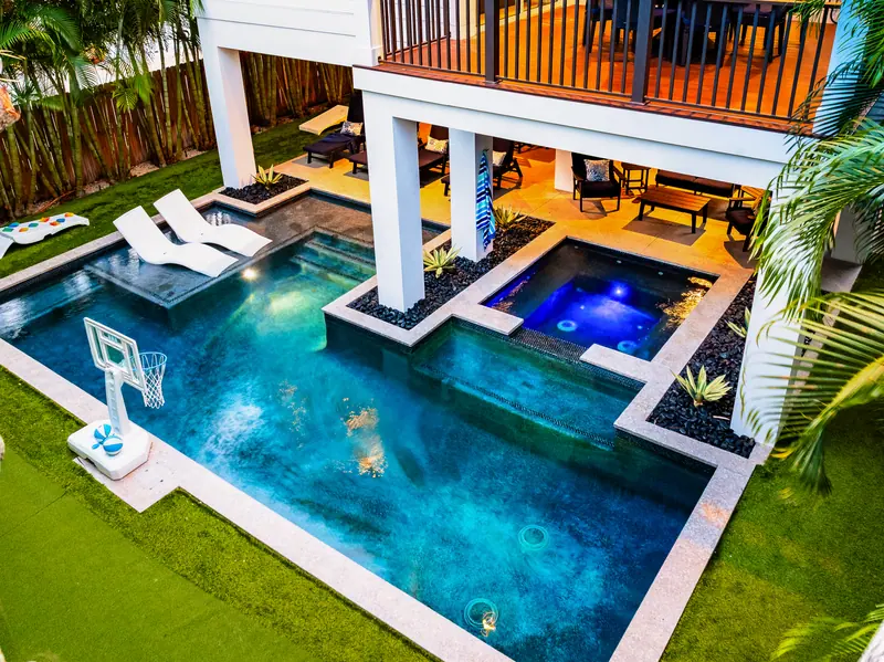 Heated pool and spa kept at 82 degrees, with tanning-ledge loungers and pool basketball