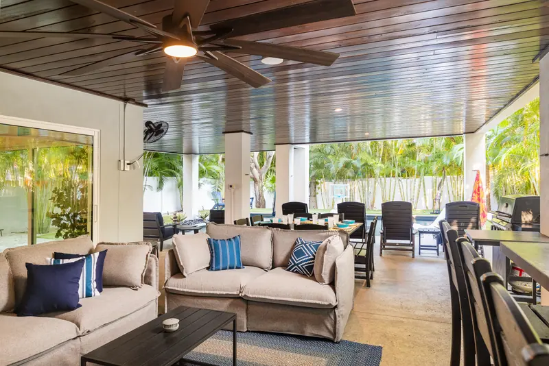Covered poolside patio with lounge seating and tropical views