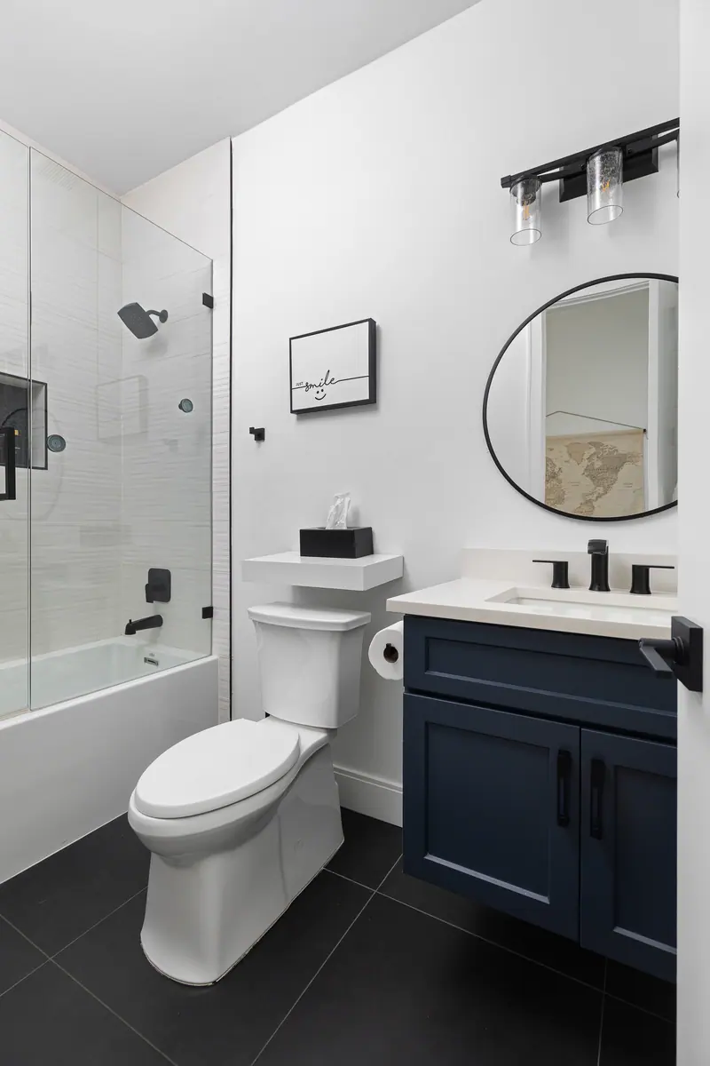 Modern bath with glass shower and navy vanity