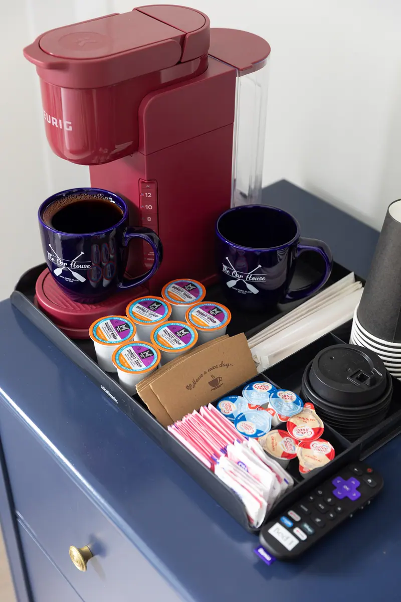 In-room Keurig setup with pods, creamers and mugs