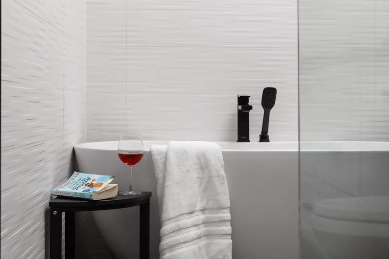 Freestanding soaking tub beside the window